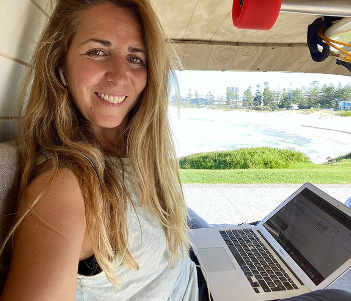 Chica trabajando en remoto en una van en Australia